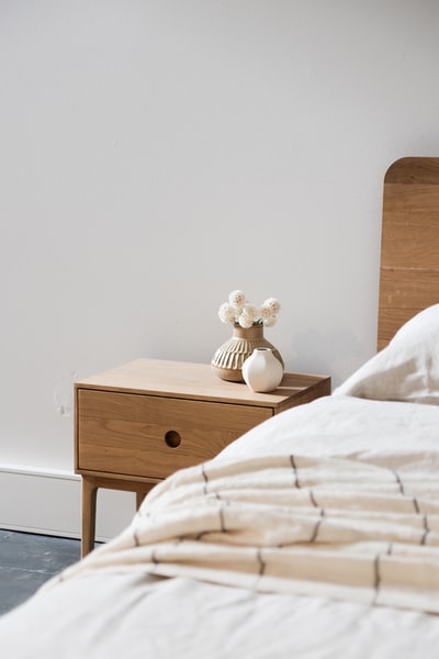 棕色木制床头柜上的白色陶瓷兔俑